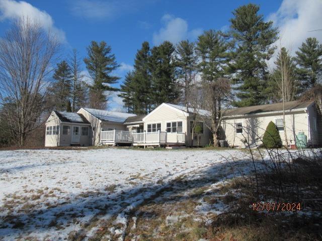 snow covered property with a deck