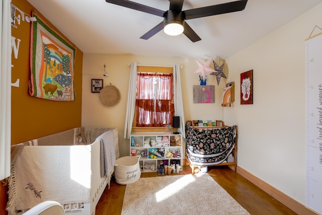 living area with dark hardwood / wood-style floors and ceiling fan