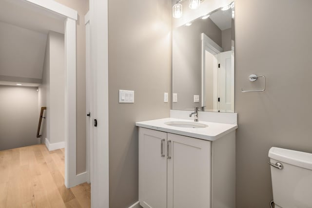 bathroom featuring hardwood / wood-style flooring, vanity, and toilet