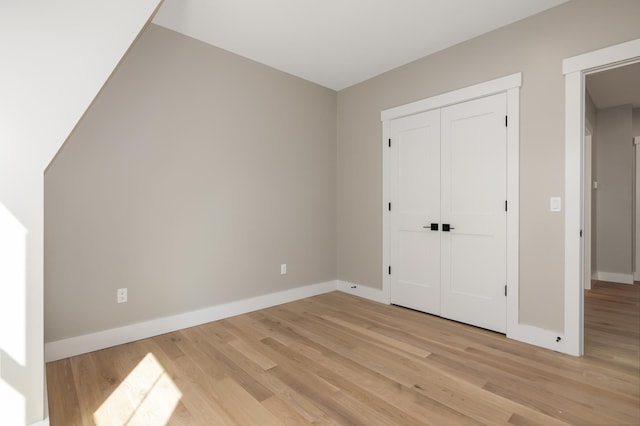 unfurnished bedroom with light hardwood / wood-style floors and a closet