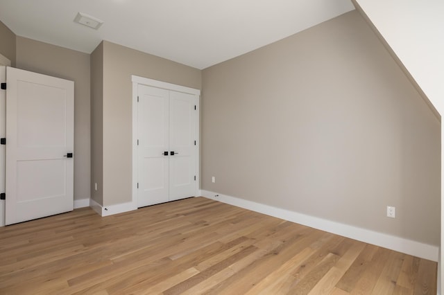 unfurnished bedroom with a closet and light hardwood / wood-style flooring