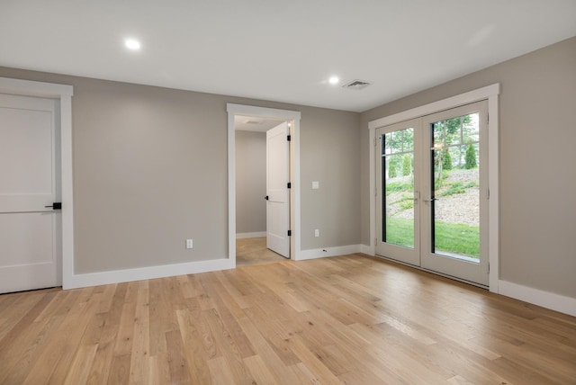 empty room with french doors and light hardwood / wood-style flooring