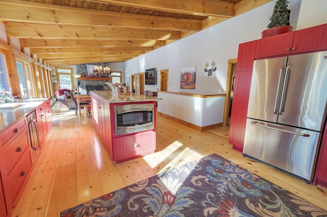 kitchen featuring stainless steel appliances, lofted ceiling with beams, a kitchen island, and light hardwood / wood-style flooring