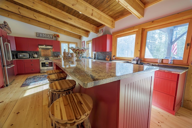 kitchen with appliances with stainless steel finishes, vaulted ceiling with beams, tasteful backsplash, light hardwood / wood-style floors, and light stone countertops