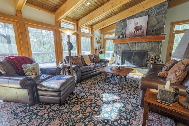 living room featuring a healthy amount of sunlight, vaulted ceiling with beams, and a fireplace