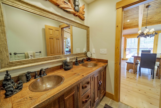 bathroom featuring vanity, hardwood / wood-style floors, and an inviting chandelier