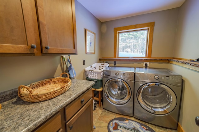 washroom featuring washing machine and dryer, cabinets, and light tile patterned flooring