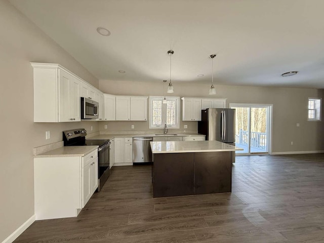 kitchen with sink, hanging light fixtures, stainless steel appliances, a center island, and white cabinets