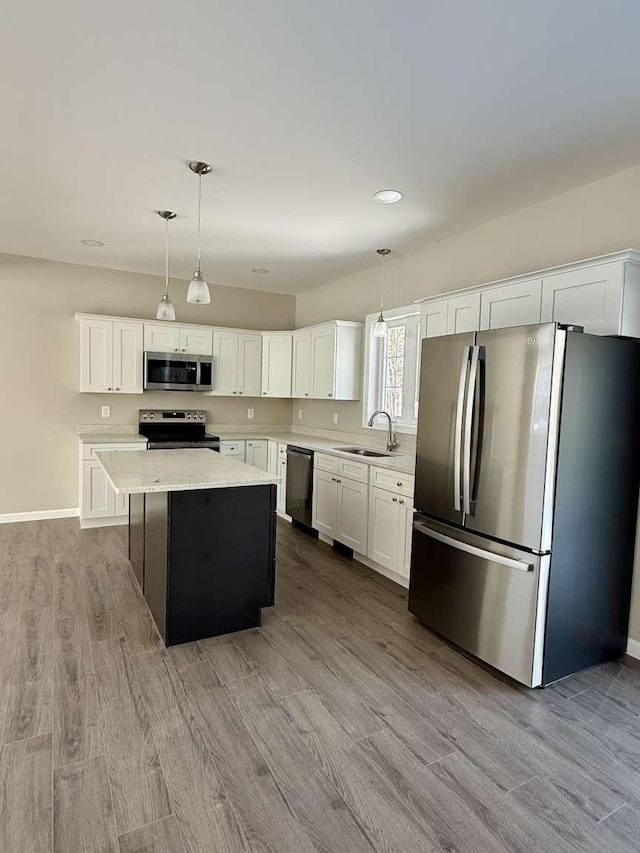 kitchen with appliances with stainless steel finishes, a center island, pendant lighting, and sink