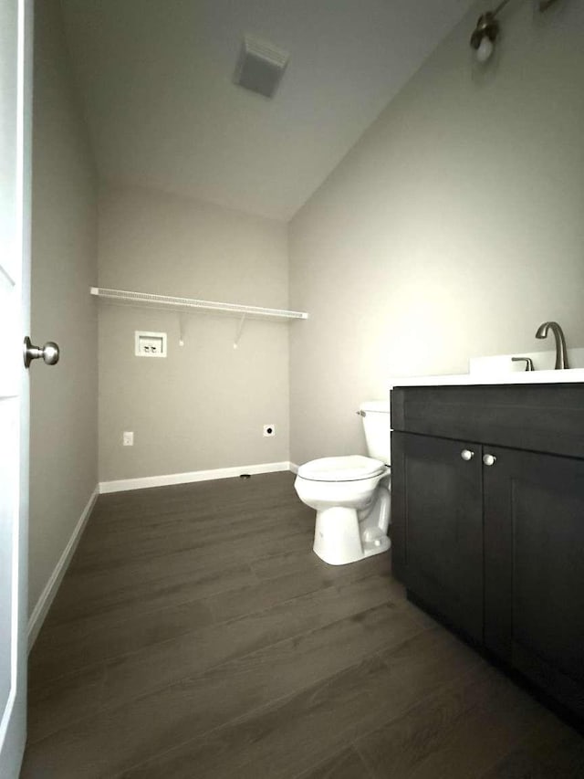 bathroom with lofted ceiling, vanity, toilet, and hardwood / wood-style floors