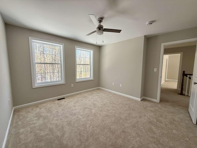 empty room with light colored carpet and ceiling fan