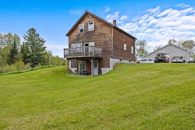 back of property featuring a deck and a lawn