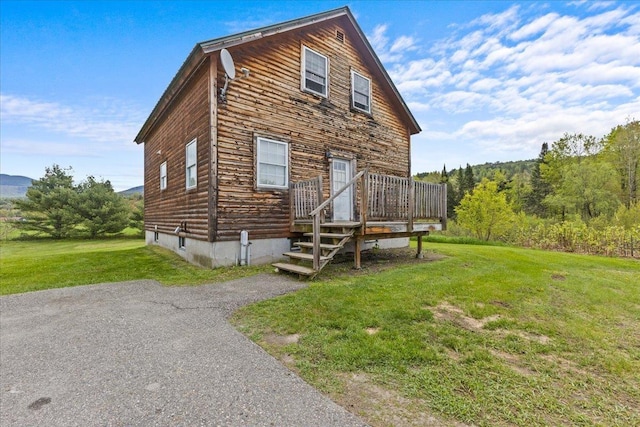 exterior space with a deck and a front lawn