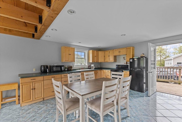 kitchen featuring sink, light tile patterned floors, light brown cabinetry, and black appliances