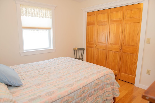 bedroom with light wood-type flooring and a closet