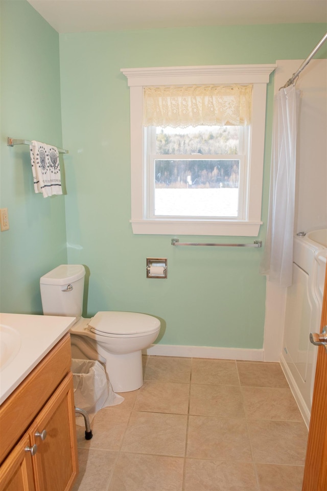 bathroom featuring vanity, a shower with shower curtain, tile patterned floors, and toilet