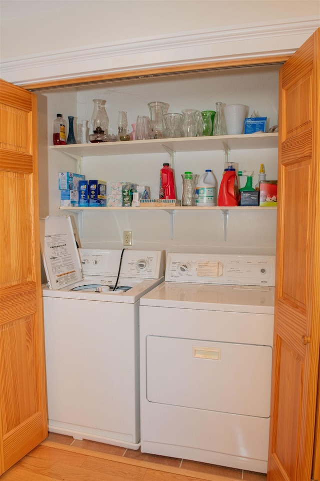 laundry area featuring separate washer and dryer and light hardwood / wood-style flooring