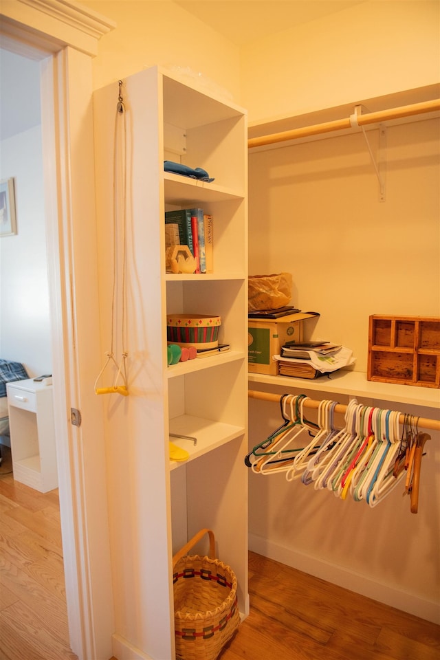 walk in closet with light hardwood / wood-style floors