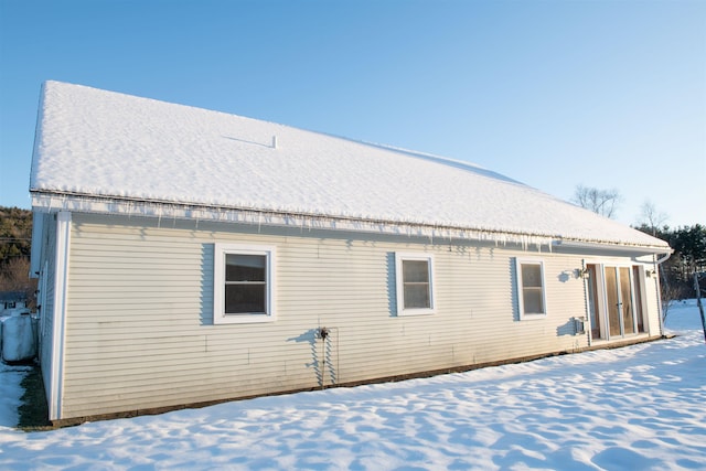 view of snow covered rear of property