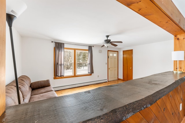 unfurnished living room with hardwood / wood-style flooring, a baseboard radiator, and ceiling fan