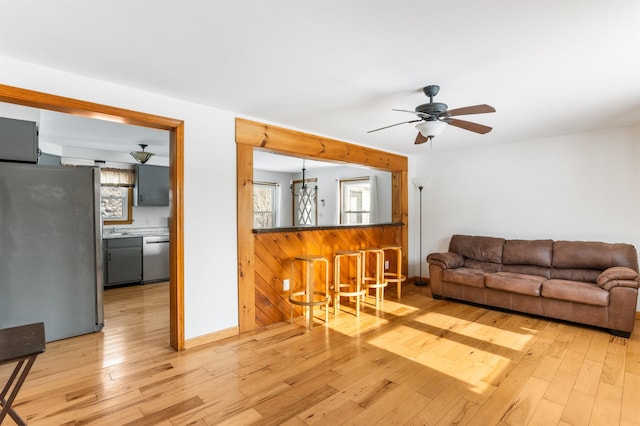 living room with ceiling fan and light wood-type flooring