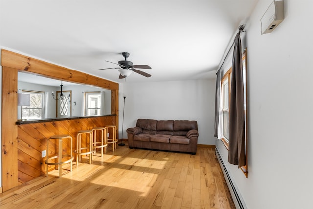 living room with a baseboard radiator, ceiling fan, and light hardwood / wood-style floors