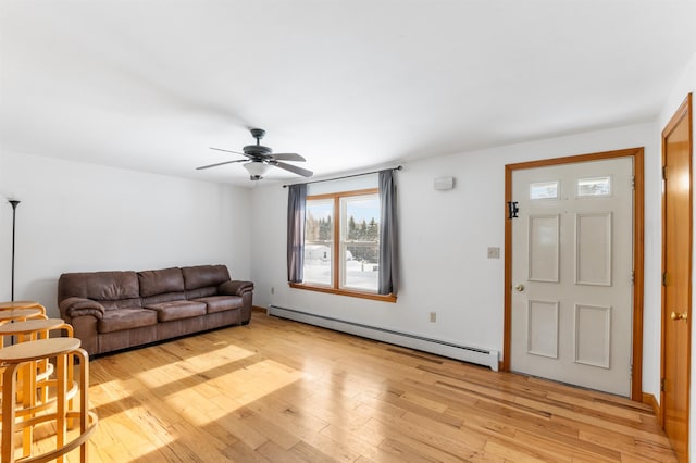 living room featuring baseboard heating, ceiling fan, and light hardwood / wood-style flooring