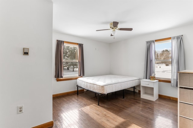 bedroom with multiple windows, wood-type flooring, and ceiling fan