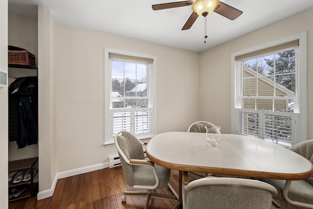 dining space with dark hardwood / wood-style flooring, ceiling fan, and baseboard heating