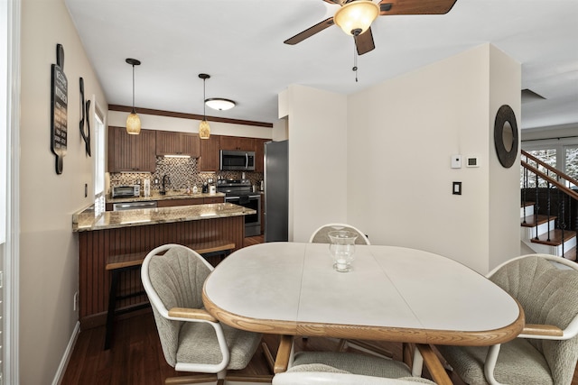 dining area with dark wood-type flooring, ceiling fan, and sink