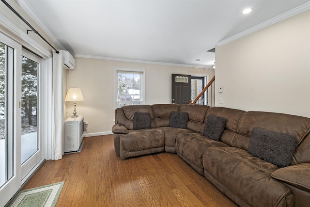 living room with a wall mounted air conditioner, crown molding, and light hardwood / wood-style floors