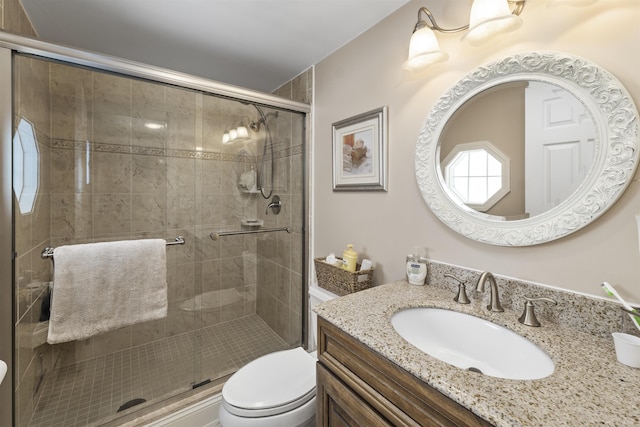 bathroom with walk in shower, vanity, and toilet