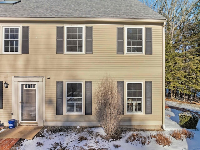 view of snow covered rear of property