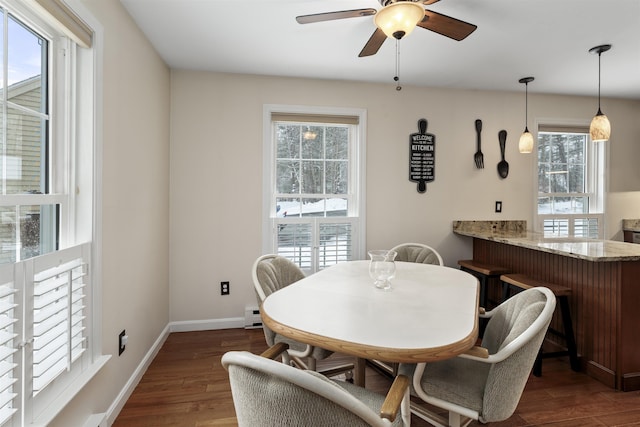 dining room featuring dark wood-type flooring, ceiling fan, and a baseboard heating unit