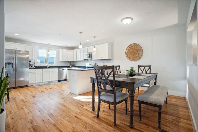 dining space with sink and light wood-type flooring