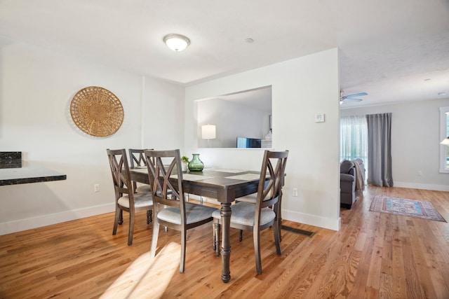 dining space with ceiling fan and light wood-type flooring