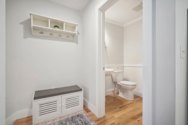 bathroom featuring hardwood / wood-style flooring, ornamental molding, and toilet