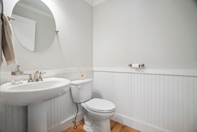 bathroom with wood-type flooring, sink, crown molding, and toilet