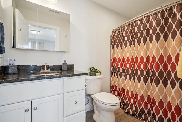 bathroom featuring vanity, hardwood / wood-style floors, and toilet