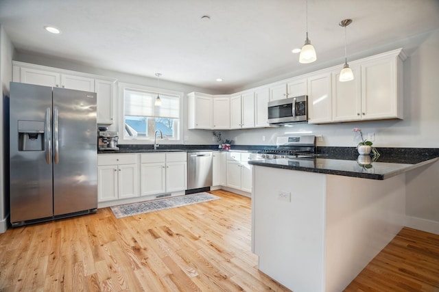 kitchen featuring pendant lighting, white cabinetry, and appliances with stainless steel finishes