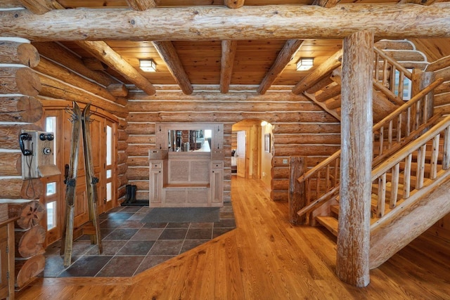 hallway with hardwood / wood-style flooring, rustic walls, wooden ceiling, and beam ceiling