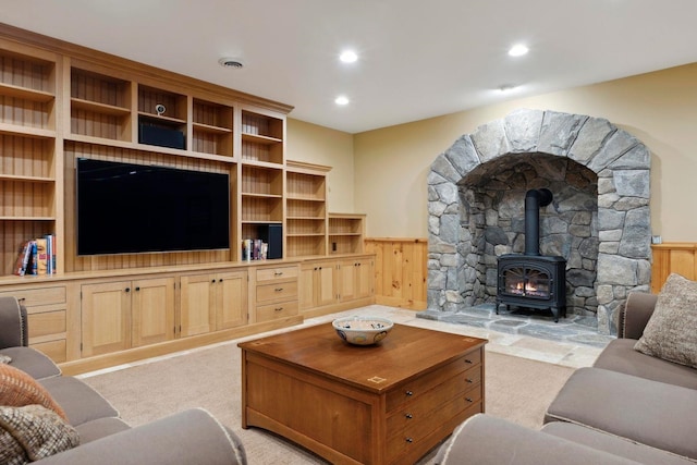 living room featuring light colored carpet and a wood stove