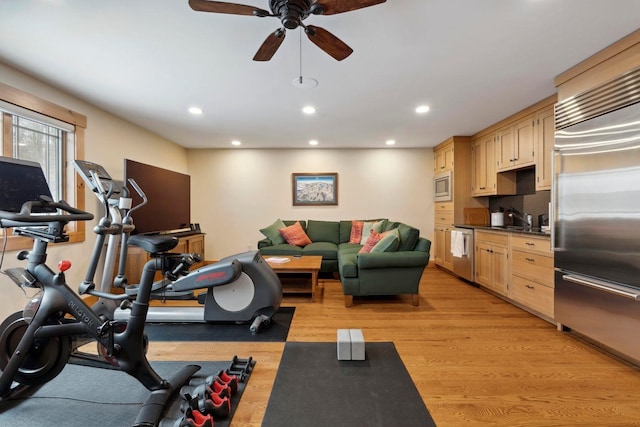 exercise area with ceiling fan, sink, and light hardwood / wood-style floors