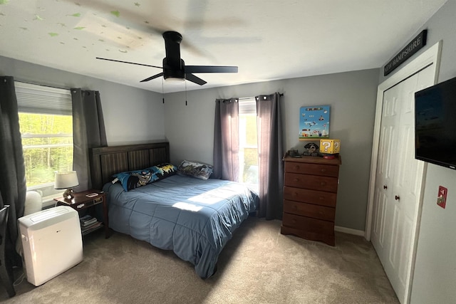 bedroom featuring ceiling fan, light colored carpet, and a closet