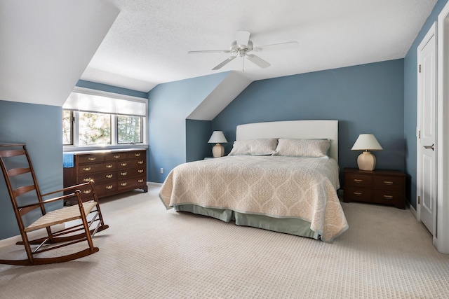 bedroom featuring lofted ceiling, a textured ceiling, light colored carpet, and ceiling fan