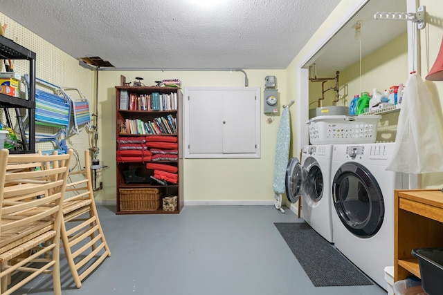 laundry area featuring washing machine and clothes dryer and a textured ceiling