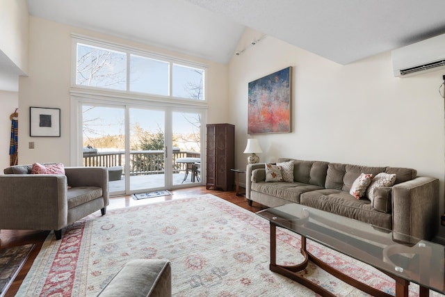 living room featuring hardwood / wood-style flooring, a healthy amount of sunlight, a wall mounted AC, and high vaulted ceiling