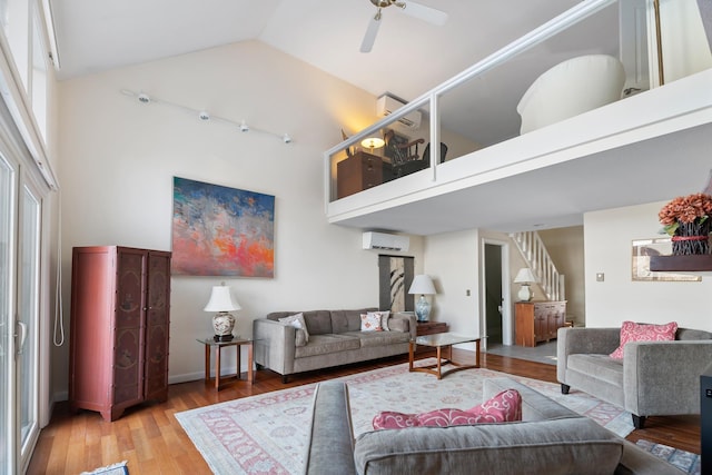 living room featuring ceiling fan, a wall mounted air conditioner, high vaulted ceiling, and wood-type flooring