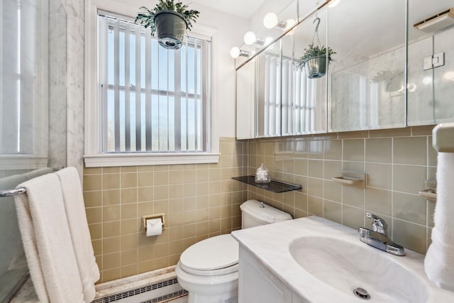 bathroom featuring tile walls, a baseboard heating unit, vanity, and toilet