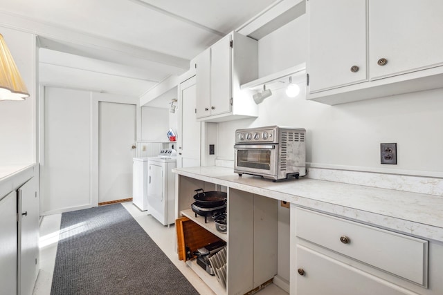 kitchen with washing machine and clothes dryer and white cabinets